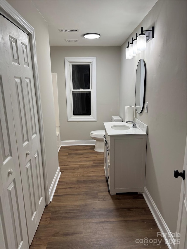 full bath featuring baseboards, vanity, toilet, and wood finished floors