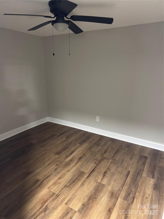 empty room with dark wood-style floors, baseboards, and a ceiling fan