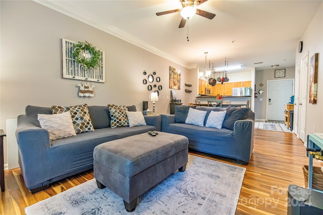 living room featuring ceiling fan, wood-type flooring, and crown molding