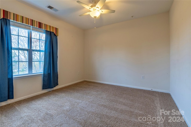 carpeted spare room featuring ceiling fan