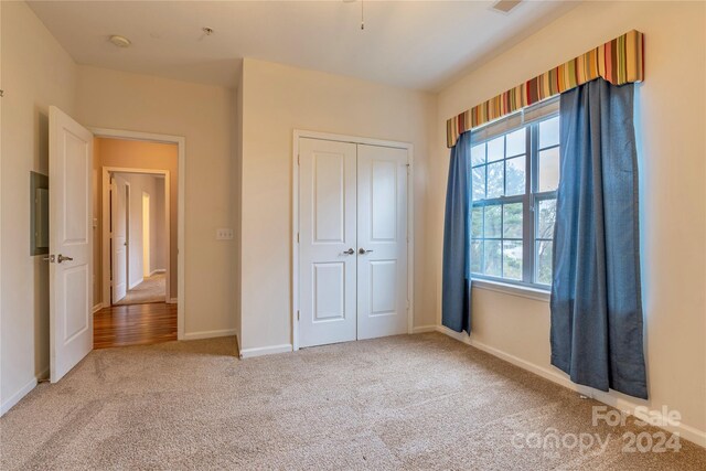 unfurnished bedroom with carpet and a closet