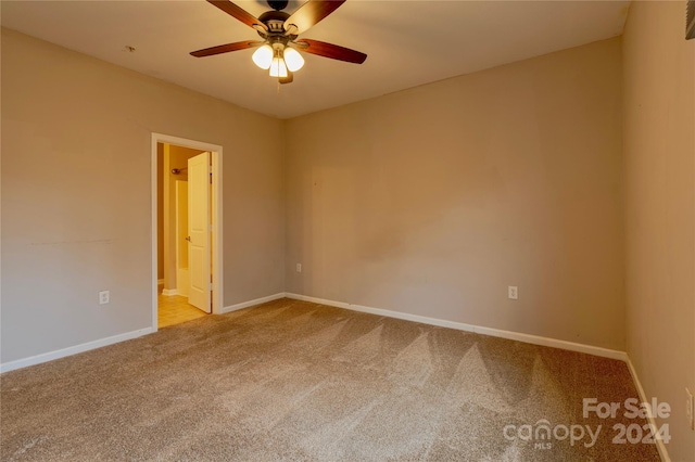 carpeted empty room featuring ceiling fan