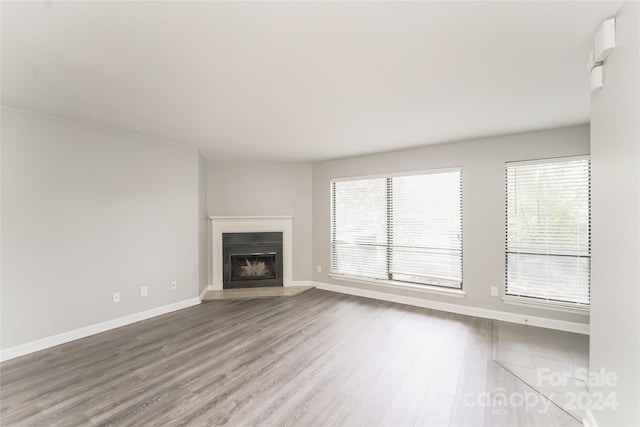 unfurnished living room with plenty of natural light and hardwood / wood-style floors