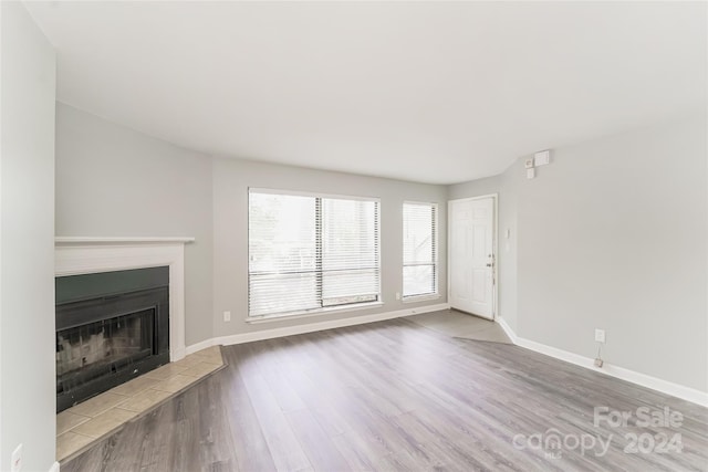 unfurnished living room with wood-type flooring and a fireplace