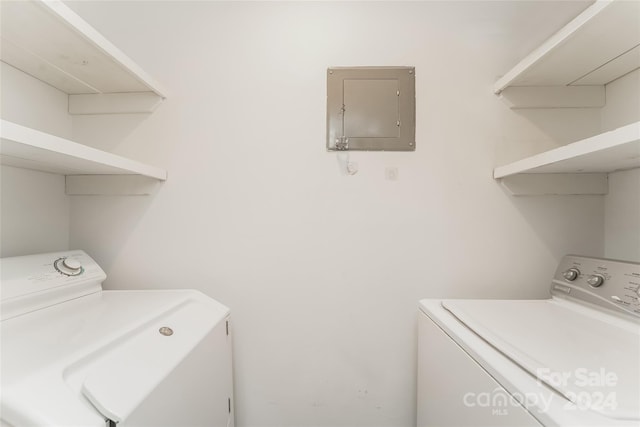 clothes washing area featuring electric panel and washing machine and dryer