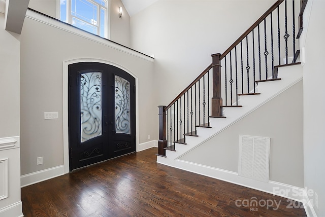 foyer featuring dark wood-type flooring and french doors