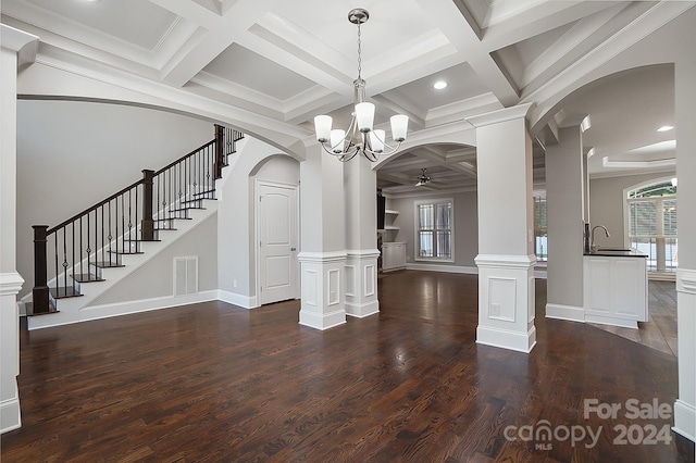 unfurnished dining area featuring decorative columns, sink, ornamental molding, and coffered ceiling