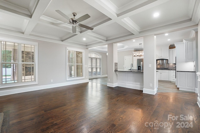 unfurnished living room featuring dark wood-type flooring, coffered ceiling, and beamed ceiling