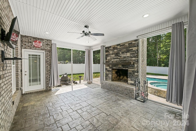 interior space featuring ceiling fan and an outdoor stone fireplace