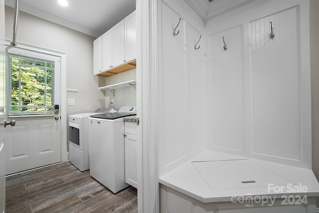 laundry room featuring dark hardwood / wood-style floors, washing machine and clothes dryer, and cabinets