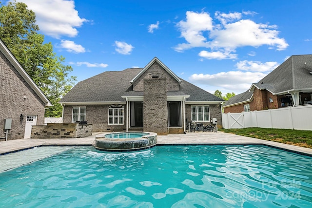 view of swimming pool featuring an in ground hot tub, a patio area, and an outdoor kitchen