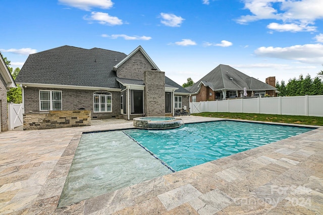 view of swimming pool with a patio area and an in ground hot tub