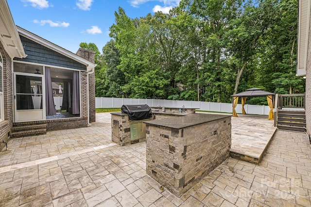 view of patio / terrace featuring a grill, an outdoor kitchen, and a gazebo