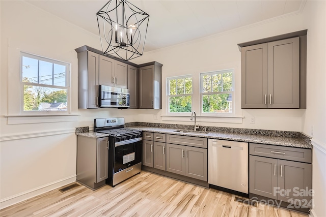 kitchen with stainless steel appliances, light wood-type flooring, a wealth of natural light, and sink