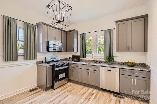 kitchen with stainless steel appliances, light hardwood / wood-style flooring, light stone counters, and sink