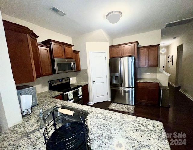 kitchen featuring tasteful backsplash, a kitchen bar, light stone countertops, and stainless steel appliances