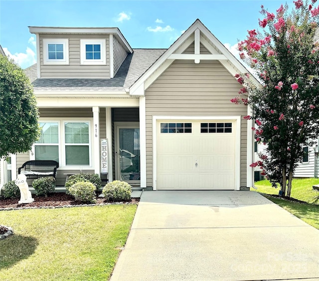 view of front of property featuring a garage, a front yard, concrete driveway, and a shingled roof