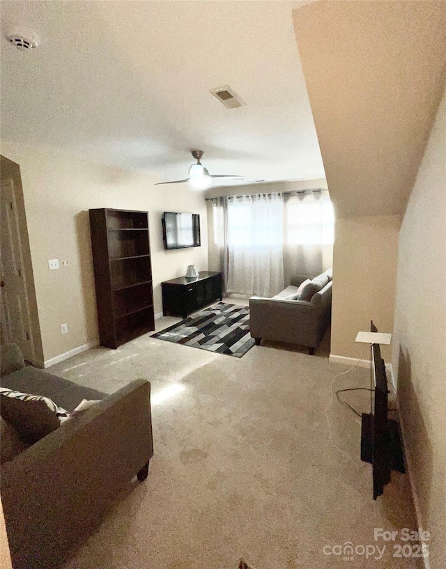 carpeted living room with baseboards, visible vents, and a ceiling fan