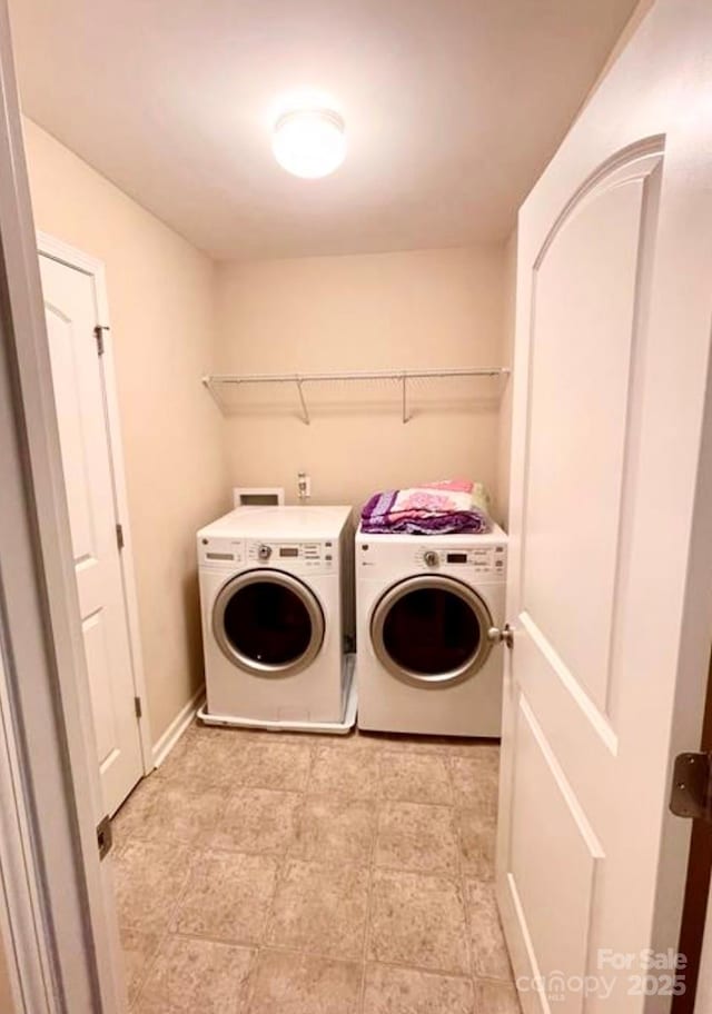 laundry area with washing machine and dryer, laundry area, and baseboards