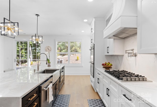 kitchen with white cabinetry, custom range hood, and stainless steel appliances