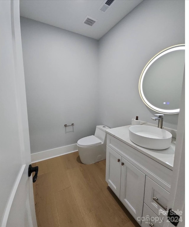 bathroom featuring vanity, toilet, and wood-type flooring