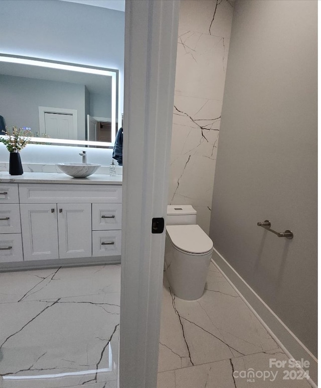 bathroom featuring tile walls, vanity, and toilet