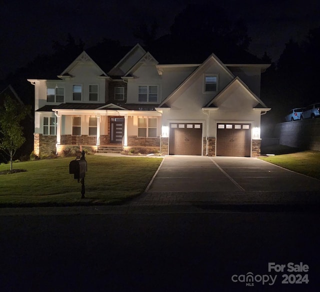 craftsman inspired home with a yard, a porch, and a garage