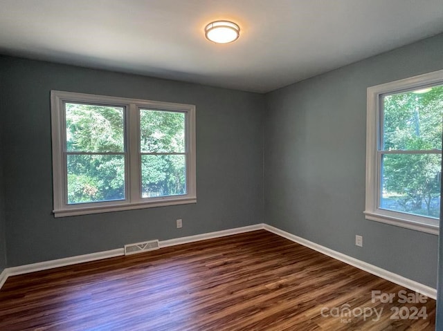 unfurnished room with dark wood-type flooring