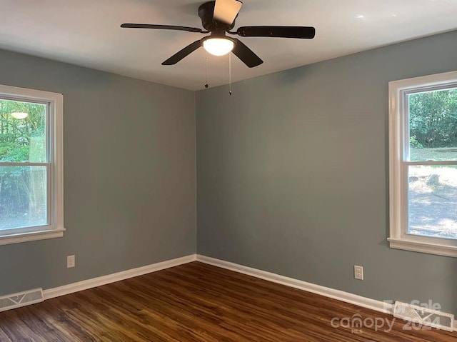 unfurnished room with ceiling fan and dark hardwood / wood-style flooring