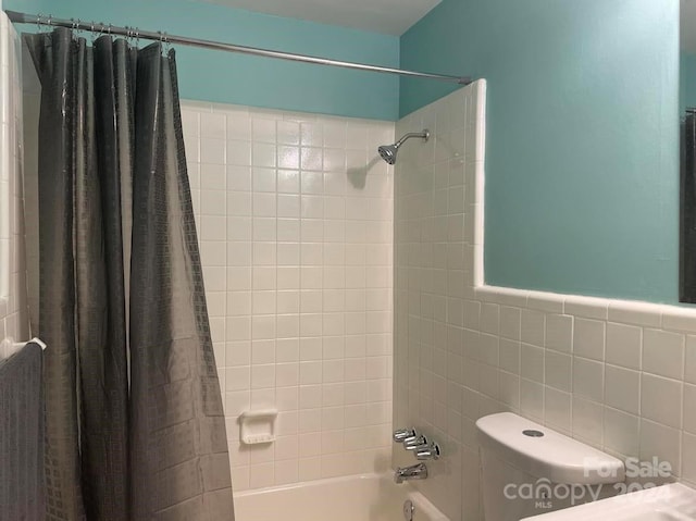 bathroom featuring toilet, tile walls, and shower / tub combo with curtain