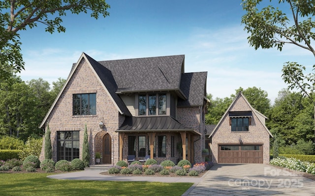 english style home with a garage, a front yard, and covered porch