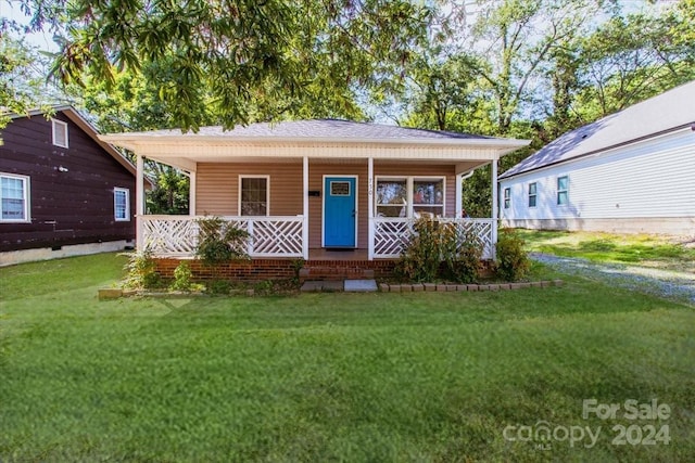 bungalow with covered porch and a front yard