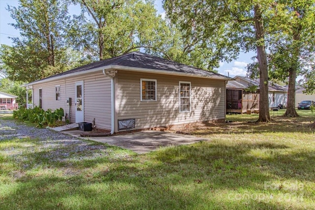 rear view of property featuring a lawn, a patio area, and central air condition unit