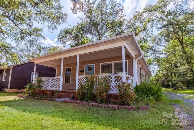 view of front of house with covered porch and a front lawn