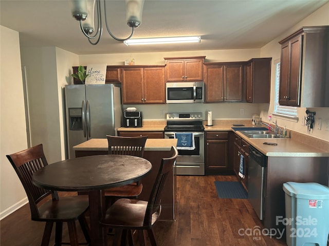 kitchen featuring a center island, sink, dark hardwood / wood-style floors, appliances with stainless steel finishes, and a chandelier