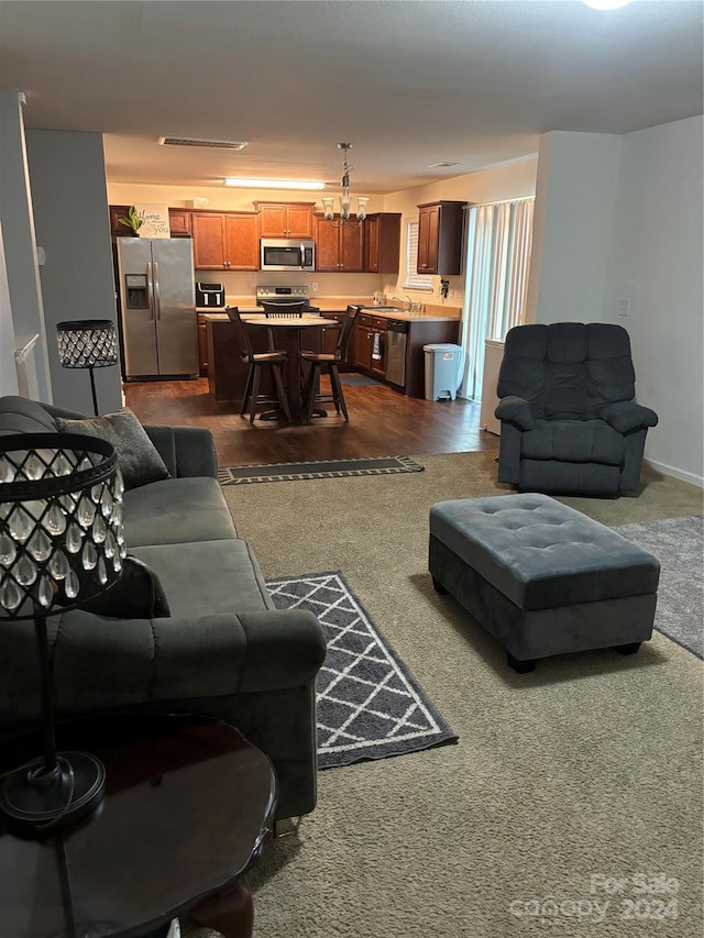 carpeted living room featuring a chandelier