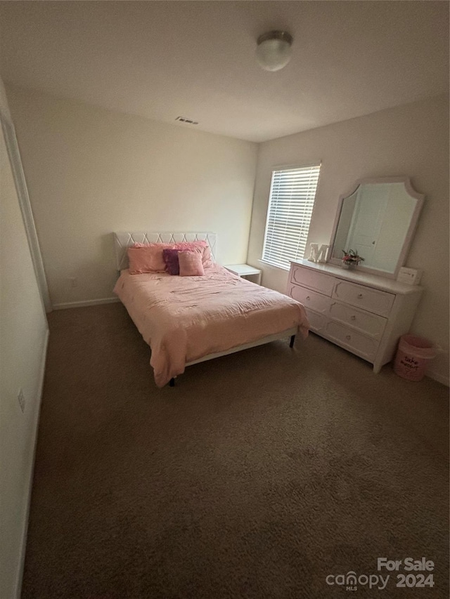 bedroom featuring dark colored carpet