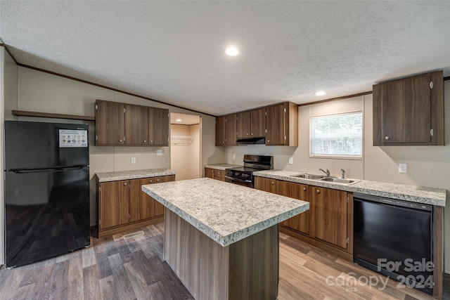 kitchen featuring lofted ceiling, a kitchen island, black appliances, sink, and a textured ceiling