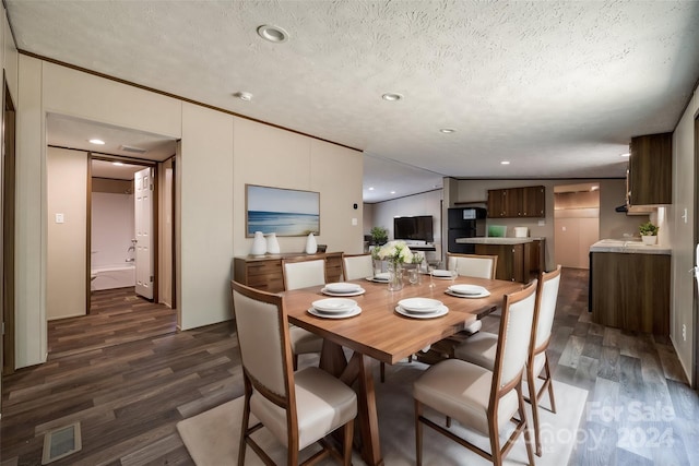 dining area with dark hardwood / wood-style floors and a textured ceiling