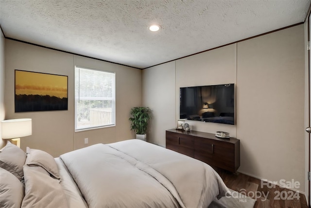 bedroom featuring wood-type flooring and a textured ceiling