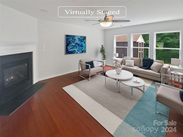 living room featuring ceiling fan and dark hardwood / wood-style floors