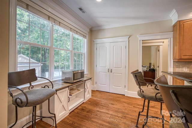 sitting room featuring light wood-type flooring and crown molding