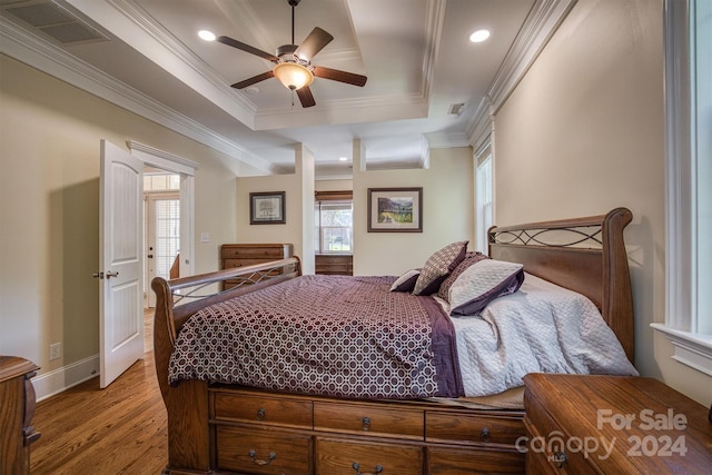 bedroom featuring a raised ceiling, ceiling fan, light hardwood / wood-style flooring, and crown molding