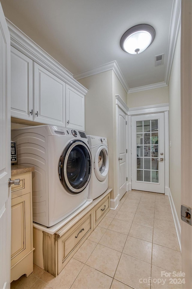 laundry area with washer and clothes dryer, light tile patterned flooring, cabinets, and ornamental molding