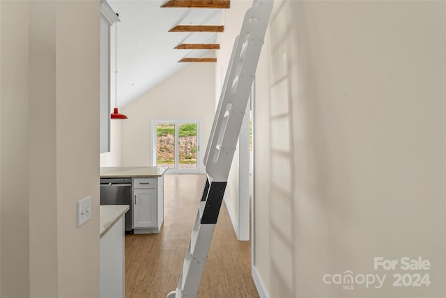 stairway with hardwood / wood-style floors, high vaulted ceiling, and beam ceiling