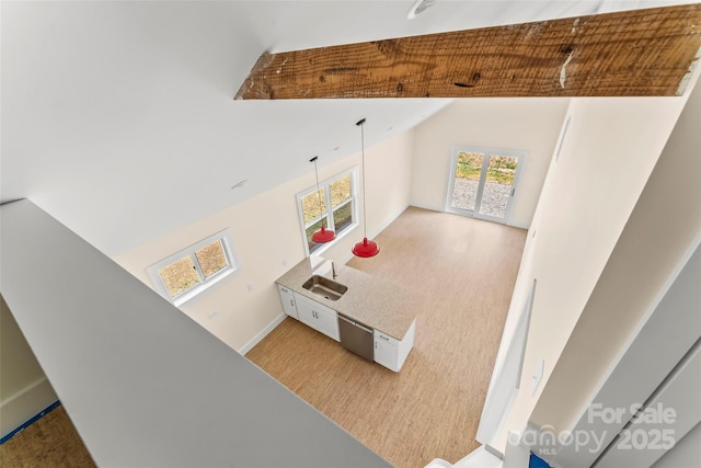 recreation room with lofted ceiling, light wood-style floors, baseboards, and a sink