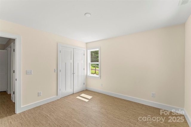 unfurnished bedroom with a closet, baseboards, and wood finished floors