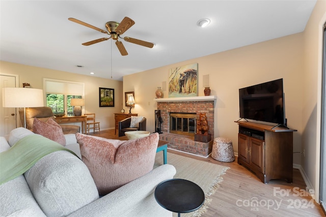 living room with ceiling fan, light hardwood / wood-style floors, and a fireplace