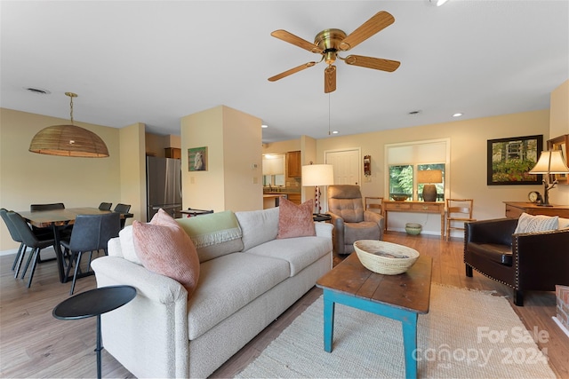 living room with ceiling fan and light hardwood / wood-style floors