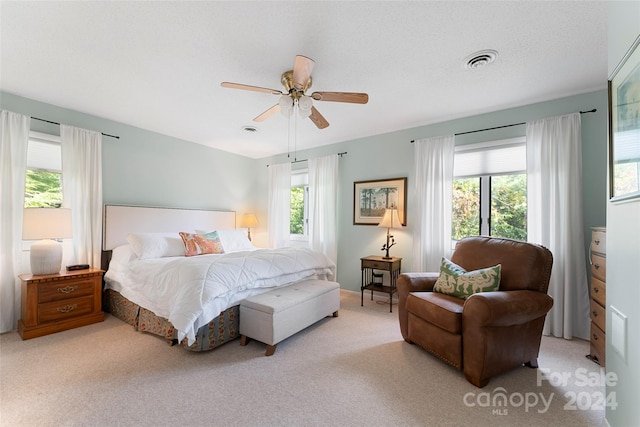 carpeted bedroom featuring a textured ceiling and ceiling fan